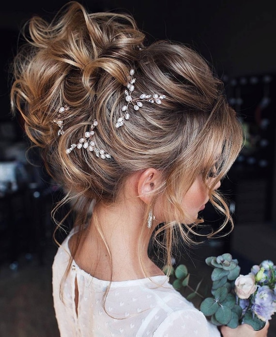 Elegant bridal updo with pearl hair pins and soft curls