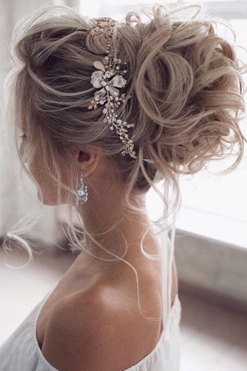 Glamorous bridal high updo with crystal hair accessory