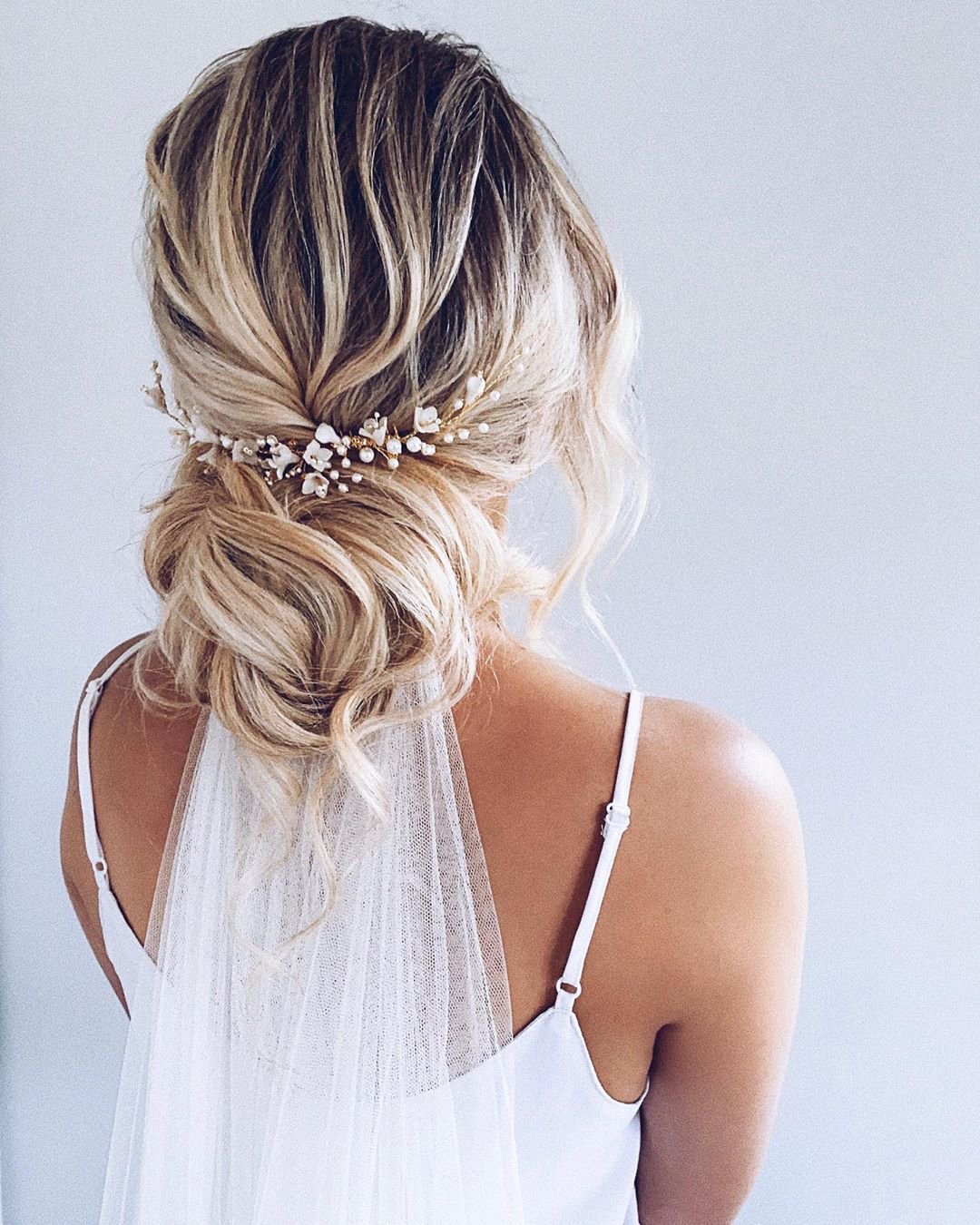 Romantic loose bridal bun with pearl hair comb and veil