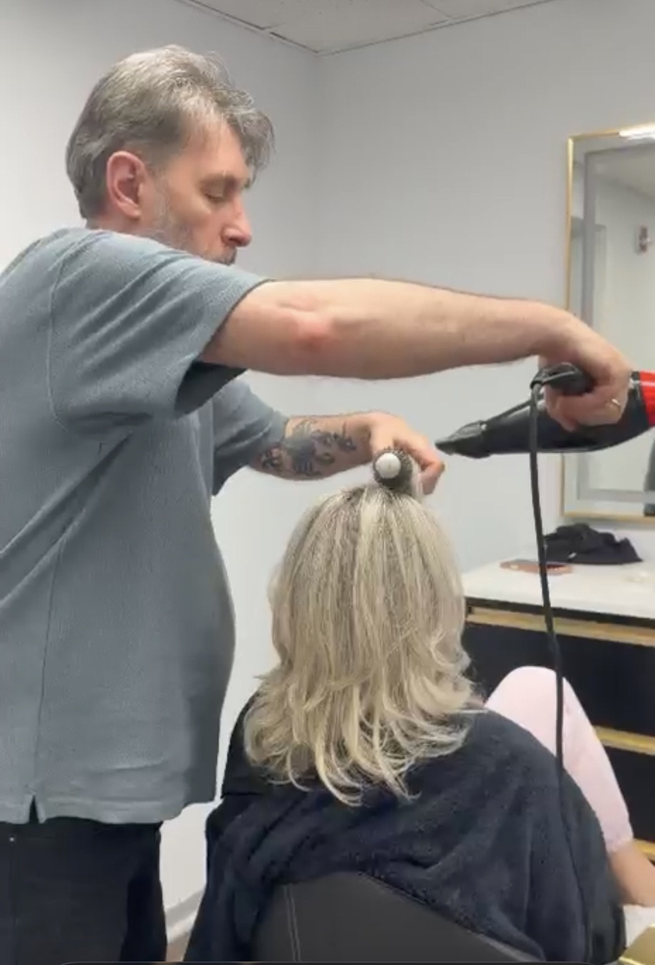 Hikmat Aghayev blow-drying and styling client hair at HIKARA Beauty Studio